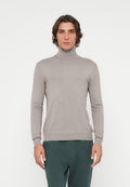 Eng anliegender, hellgrauer Rollkragenpullover aus geripptem Strickstoff. Mit langen Ärmeln und dezentem Logodetail auf der Brust.