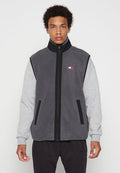 Grauer Fleece-Weste mit grauen Ärmeln, hohem Kragen und Frontreißverschluss. Verfügt über schwarze Akzente und ein kleines Logopatch auf der linken Brust.