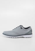 Herren Golfschuh, graues synthetisches Obermaterial mit Perforationen, weiße Zwischensohle und strukturierte graue Fersenkappe. Mit schwarzen Schnürsenkeln und Ösen.
