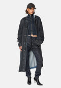 Dunkelblauer Jeansmantel, kurzer navyfarbener Reißverschlussoberteil, passende Jogginghose und spitze schwarze Absätze. Baseballkappe mit ausgefransten Rändern und Logodetail.