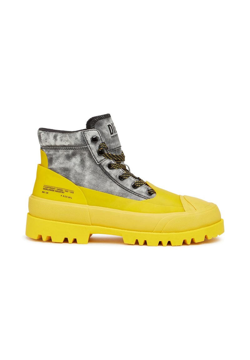 Hochschaftstiefel mit einer gelben Gummisohle, grauem strukturiertem Obermaterial, schwarzen Schnürsenkeln und einer klobigen Sohle mit tiefen Rillen für besseren Halt.