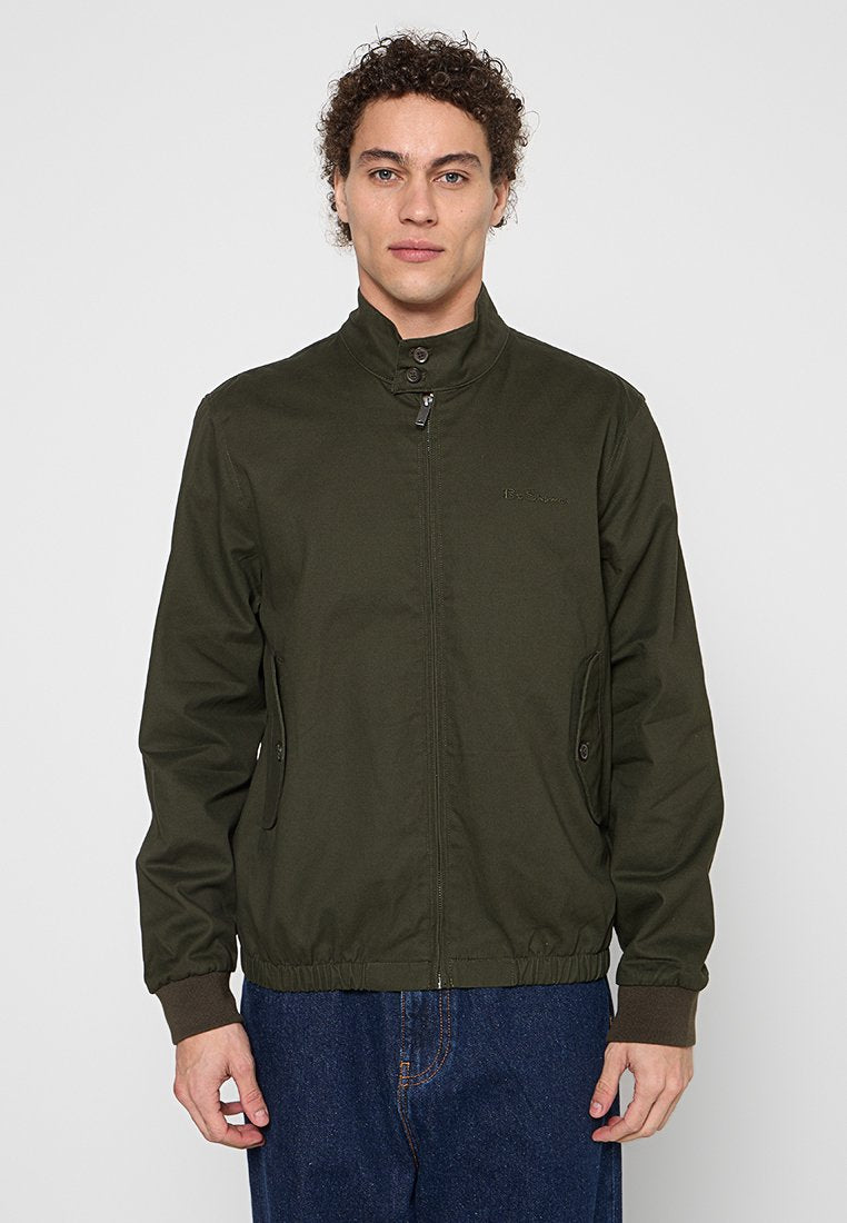 Dunkelgrüne, leichte Jacke mit hohem Kragen, Reißverschluss und seitlichen Taschen. Verfügt über gerippte Ärmelbündchen und einen gerafften elastischen Saum.