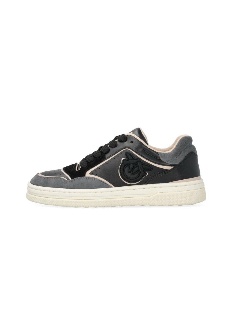 Schwarzer und grauer Sneaker aus glattem Leder und Wildledertexturen, mit kontrastierenden beigen Akzenten, schwarzen Schnürsenkeln und einem runden Logo an der Seite.