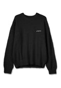 Schwarzer, flauschiger Strickpullover mit rundem Ausschnitt und langen Ärmeln. Verfügt über ein kleines weißes Logo auf der linken Seite. Weiche Textur.