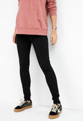 Schwarze Slim-Fit-Jeans, pinke Kapuzenjacke mit frontaler Tasche, schwarze Sneaker mit strukturiertem Muster und beigen Sohlen, die eine figurbetonte Silhouette präsentieren.