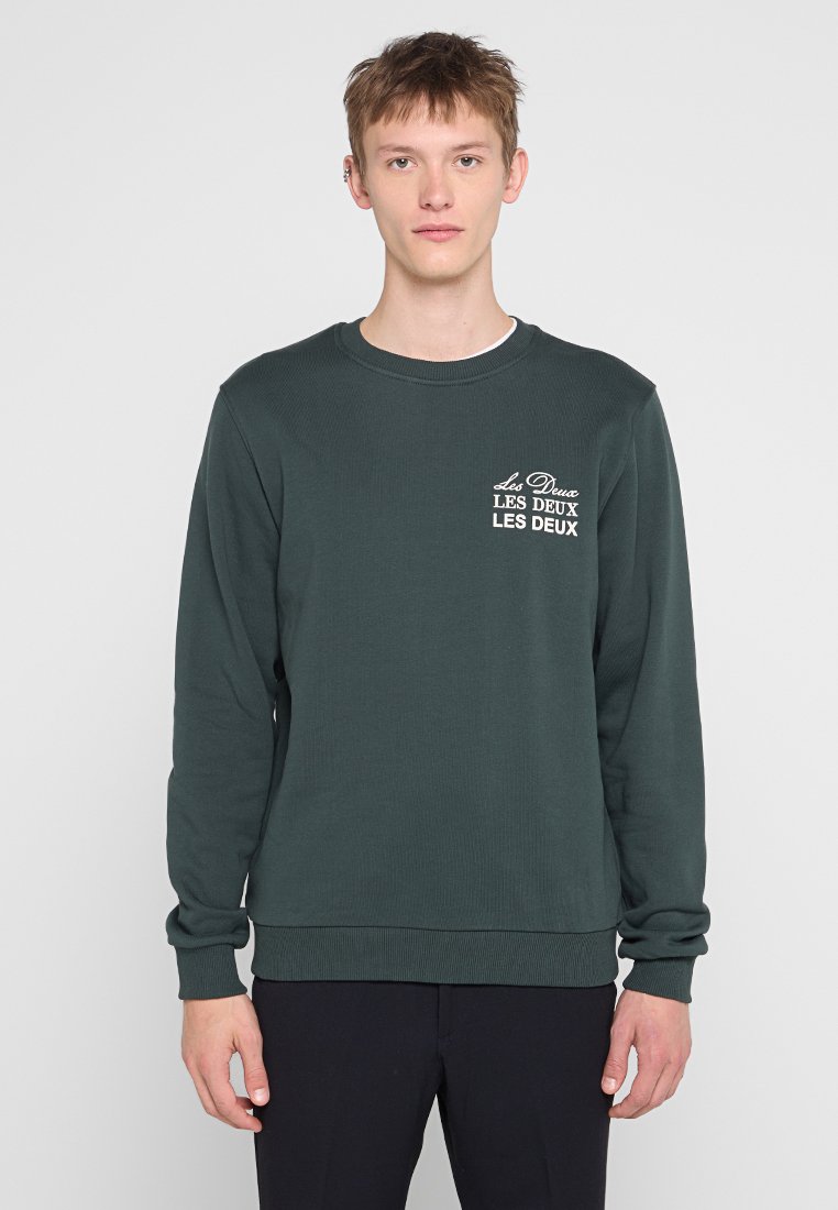Grüner Langarm-Crewneck-Sweatshirt aus geripptem Stoff, mit einem Front-Logo in weißem Text. Glatter Stoff und reguläre Passform.