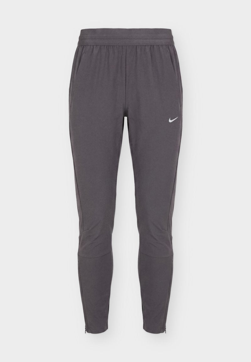Dunkelgraue, schmal zulaufende Sporthose mit elastischem Bund, Seitentaschen, dezenten Knie-Nähten und kleinem weißem Nike-Swoosh am rechten Oberschenkel.