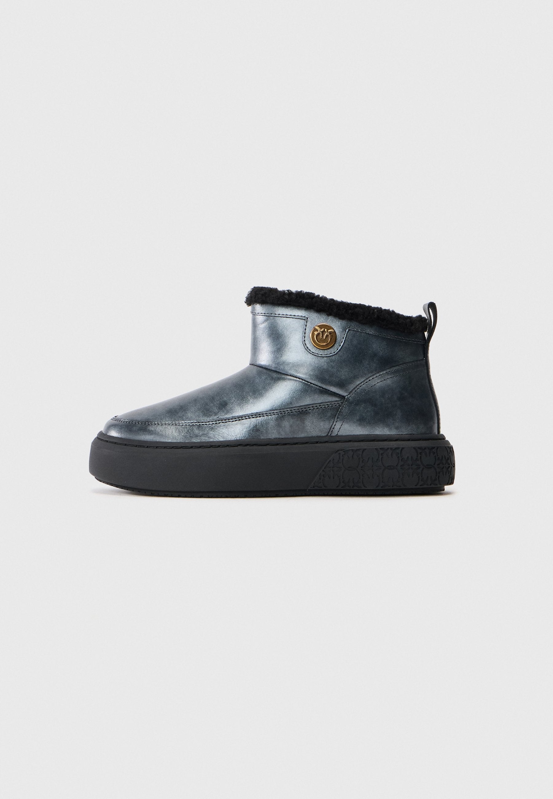 Dunkelblaue Knöchelstiefel mit schwarzem Fellfutter, dicker schwarzer Sohle und einem runden goldenen Emblem an der Seite.
