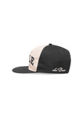 Schwarz-beige Snapback-Cap mit flachem Schirm, auf der Seite mit besticktem "LEO DEUX" und fetter Schrift auf der Vorderseite.