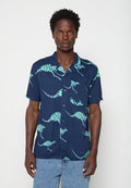Mann trägt ein kurzärmeliges, marineblaues Hemd mit türkisfarbenen, gepunkteten Känguru-Prints und hellblauen Jeans.