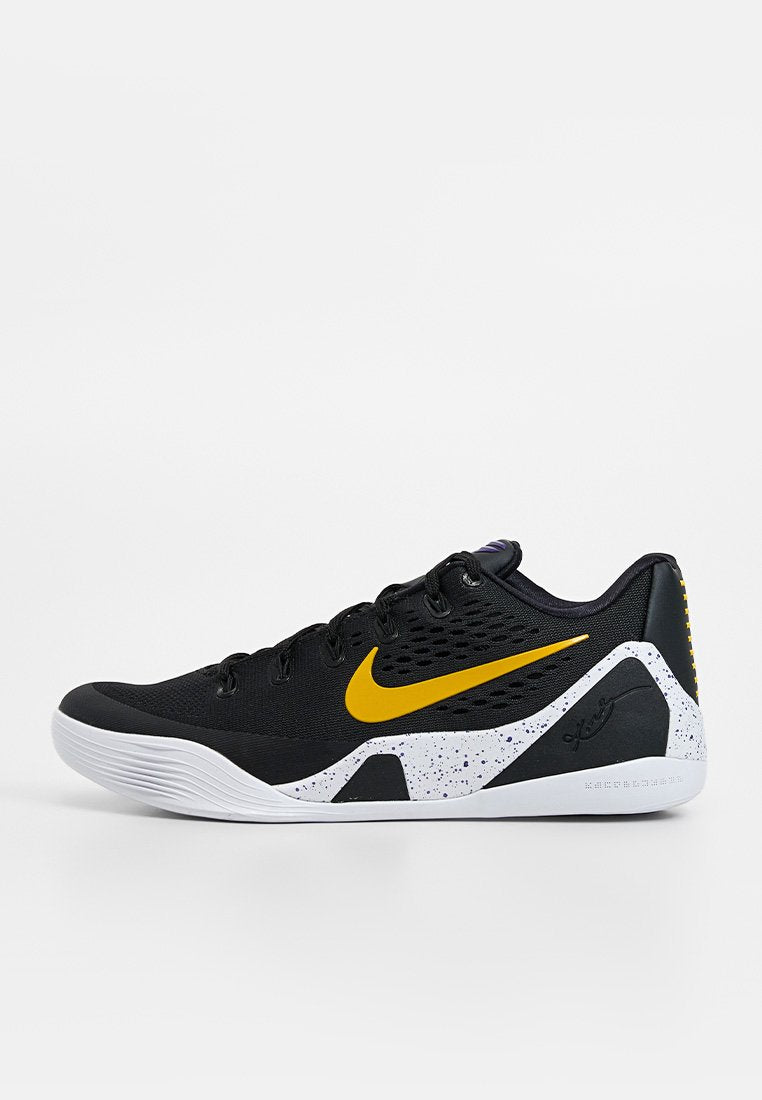 Schwarzer Sportschuh mit gelbem Nike-Swoosh, weiß gesprenkelter Zwischensohle und niedrigem Schnitt, seitlich auf weißem Hintergrund dargestellt.