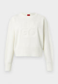 Weißer, gestrickter Pullover mit langen Ärmeln, gerippten Bündchen und Saum, versehen mit erhabenem "HUGO"-Text auf der Vorderseite und einem roten Etikett am Halsausschnitt.
