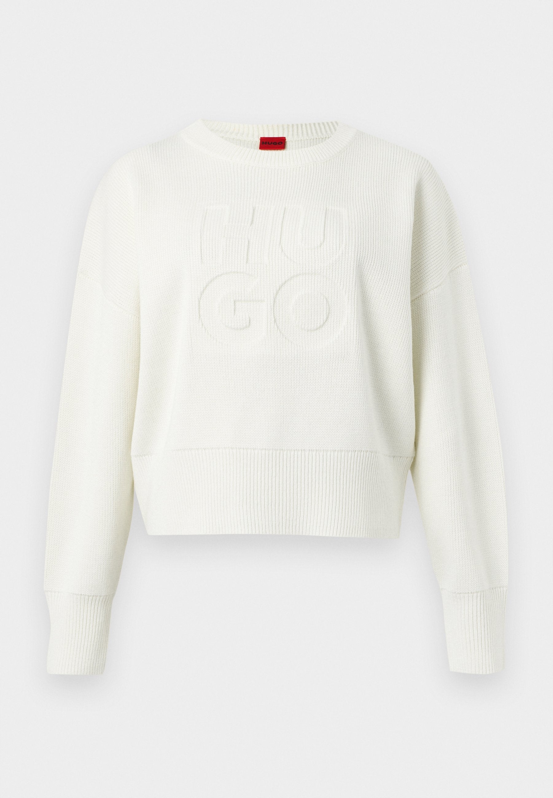 Weißer, gestrickter Pullover mit langen Ärmeln, gerippten Bündchen und Saum, versehen mit erhabenem "HUGO"-Text auf der Vorderseite und einem roten Etikett am Halsausschnitt.