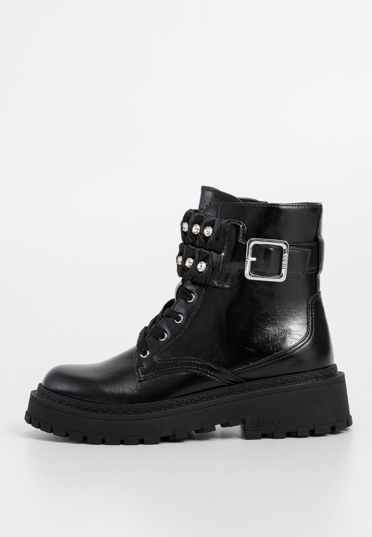 Schwarze Leder-Stiefeletten mit runder Zehenform, Schnürung vorne, kräftiger Sohle und einem dekorativen Riemen mit Nieten sowie einer silbernen Schnalle.