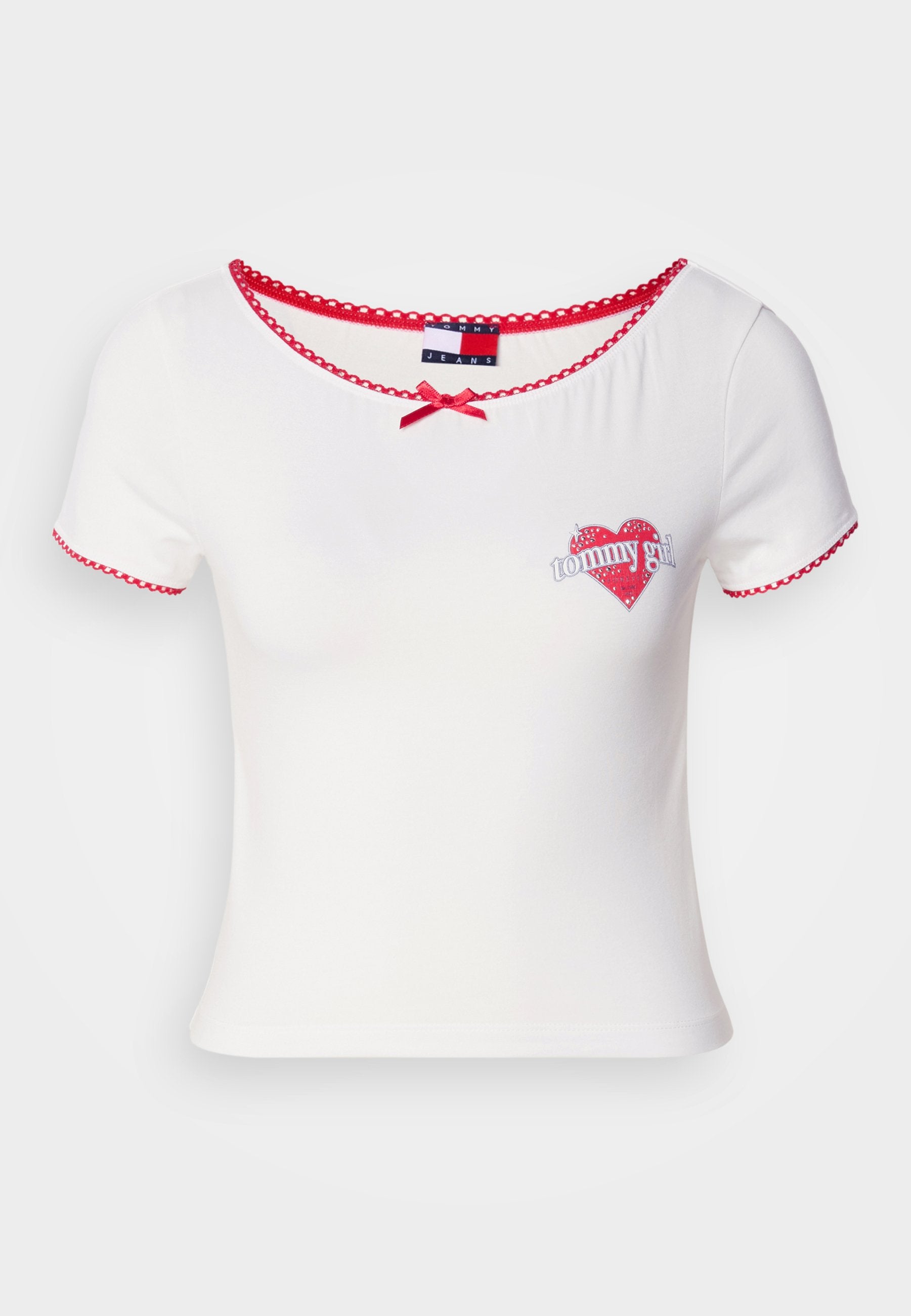 Weiße Kurzarm-T-Shirt mit rotem gewelltem Saum und einem kleinen Herz-Graphic mit dem Text "tommy girl"; Schleifenakzent am Ausschnitt.