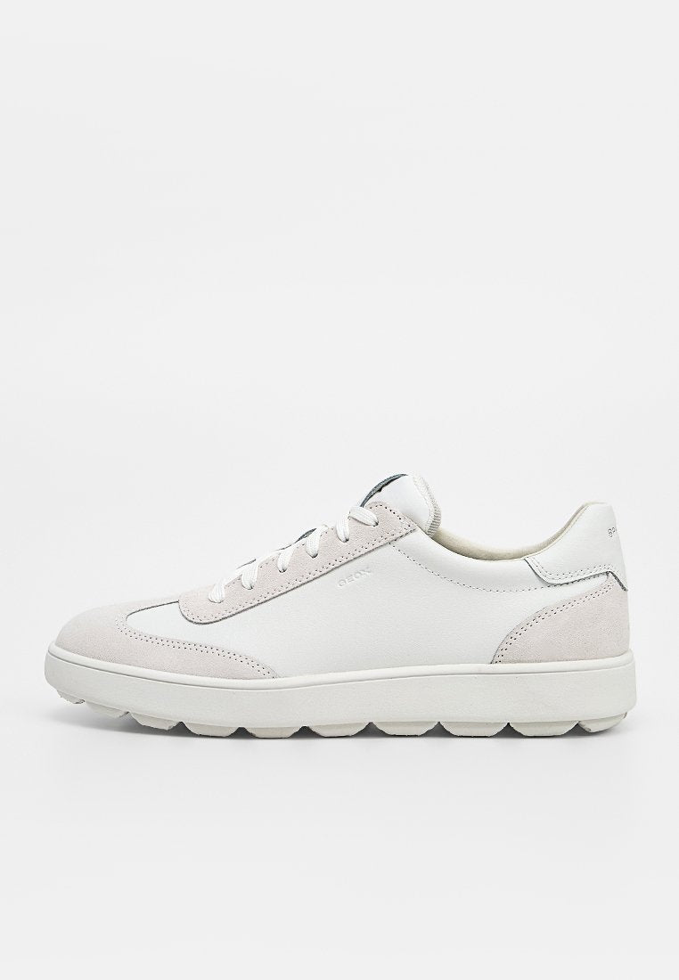 Weißer Sneaker mit niedrigem Schnitt, hellgrauen Veloursakzenten, Schnürverschluss und dicker profillierter Sohle, von der Außenseite gezeigt.