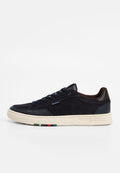 Marineblaue Wildleder-Sneaker mit perforierten Details, braunen Lederakzenten, cremefarbener Gummisohle und mehrfarbigen Streifen an der Seite der Sohle.