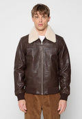 Braune Lederjacke mit einem cremefarbenen, künstlichen Schafslederkragen, Reißverschluss und gerippten Bündchen. Sie hat eine glatte Textur und Seitentaschen.