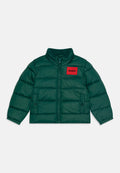 Grüne Puffjacke mit einem roten Logo-Patch auf der Brust, hohem Kragen, Reißverschluss und Seitentaschen mit glatter, glänzender Textur.