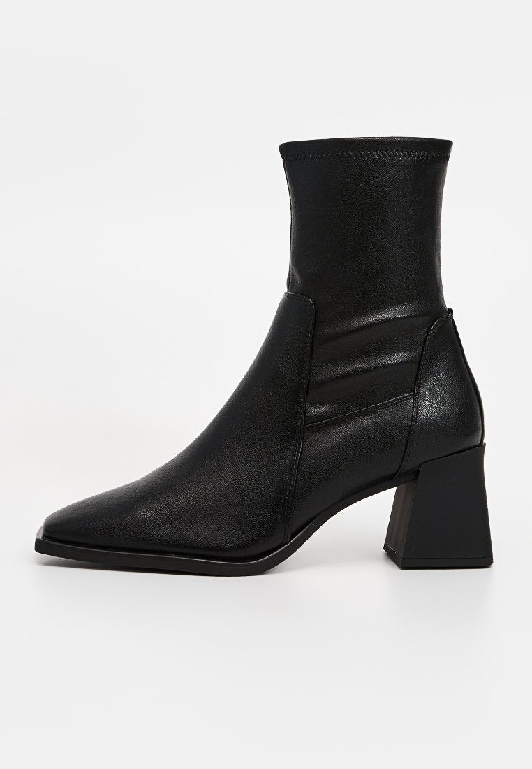 Schwarze Knöchelstiefel mit spitzem Zeh, aus glattem Leder gefertigt, mit gepolstertem Knöchel und Blockabsatzdesign.