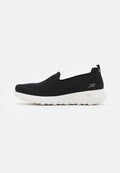 Schwarze Slip-On Sneakers mit einem strukturierten Mesh-Obermaterial, weißer Sohle und einem dezenten Logo an der Seite. Abgerundete Zehenpartie und flaches Design.