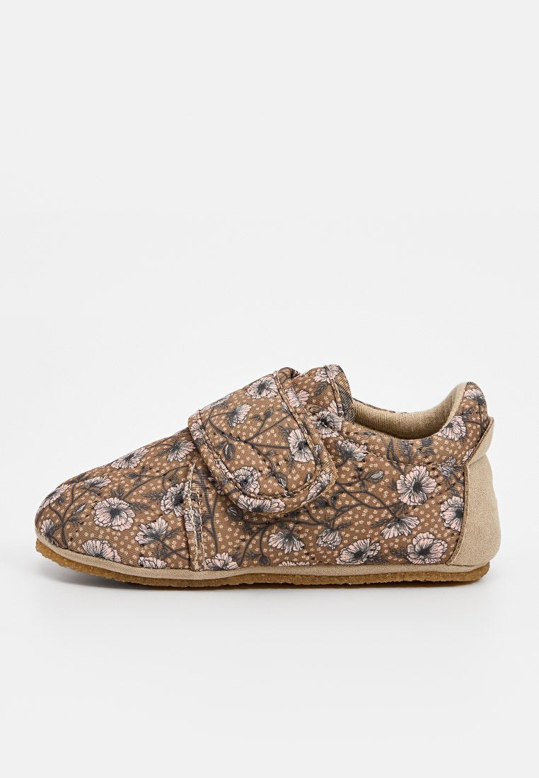 Braunes, blühendes Schuhmuster mit einem Klettverschluss. Obermaterial aus weichem Stoff, abgerundete Form und strukturiertes Sohlenprofil für Grip und Komfort.