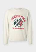Helle Cremefarbenes Sweatshirt mit grober Strickstruktur. Besitzt ein grafisches Design mit "JACKSON HOLE" und "WYOMING" in Rot und Grün. Runde Halslinie.