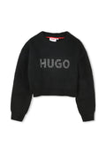 Schwarzer, verkürzter Pullover mit gerippter Textur, runder Ausschnitt und langen Ärmeln. Auf der Vorderseite ist das Logo "HUGO" in silbernen Nieten zu sehen.