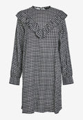 Schwarz-weißes Hahnentrittmuster-Kleid mit langen Ärmeln, Rüschenausschnitt und Manschettendetails. Aus weichem Stoff mit einer lässigen Silhouette gefertigt.