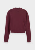 Bordeauxrotes cropped Sweatshirt mit langen Ärmeln, aus weichem Stoff, mit einem hohen Kragen und einem geprägten Logo auf der Vorderseite.