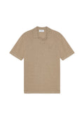 Beiges Poloshirt aus weichem Stoff, mit klassischem Kragen und kurzen Ärmeln, versehen mit einer dezenten Logo-Stickerei auf der Brust.