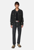 Schwarze Jeansjacke mit zwei Brusttaschen, schwarzes Tanktop, dunkle Jeans und gemusterte Clogs. Lässiger Schnitt und minimalistisches Design.