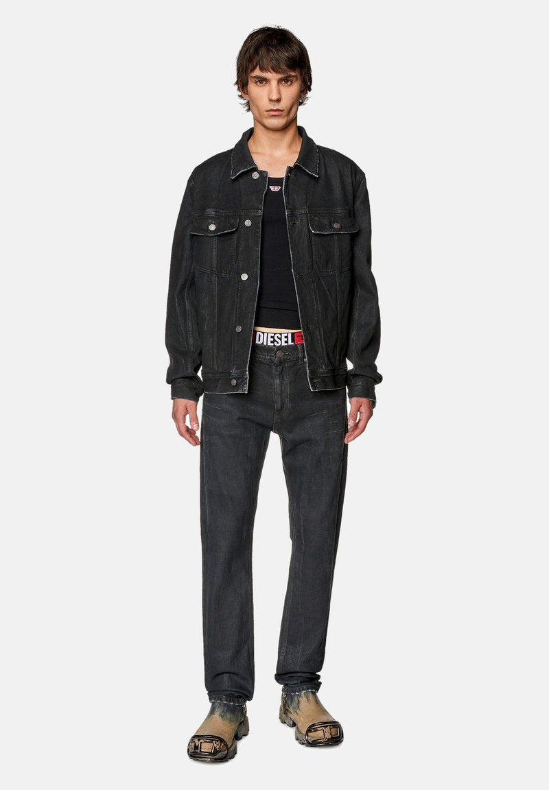 Schwarze Jeansjacke mit zwei Brusttaschen, schwarzes Tanktop, dunkle Jeans und gemusterte Clogs. Lässiger Schnitt und minimalistisches Design.