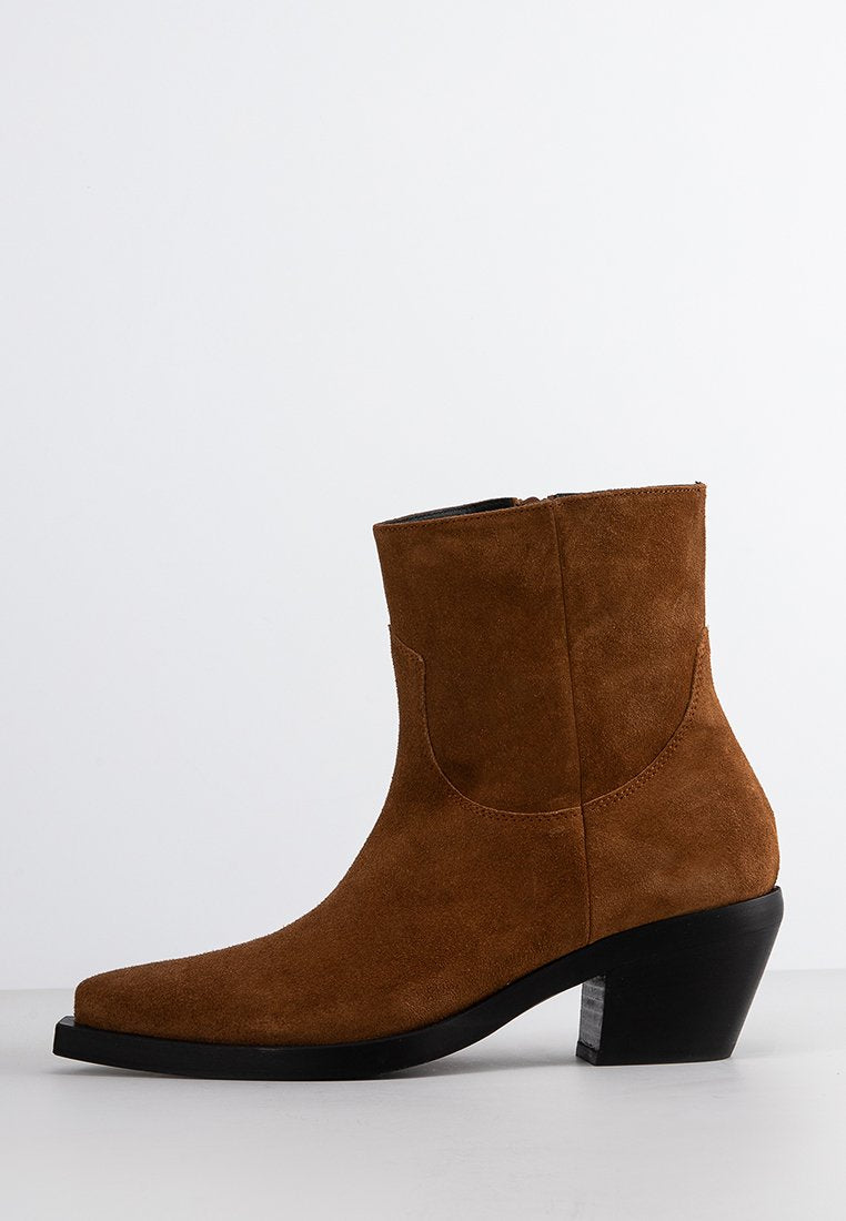 Braune Wildleder-Ankle Boots mit spitzem Zeh, schwarzem Blockabsatz und seitlichem Reißverschluss auf einem schlichten weißen Hintergrund.
