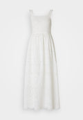Weißes Maxikleid mit dünnen Trägern, Rüschendetails und gestickten Spitzenmustern. Es hat ein tailliertes Oberteil und einen ausgestellten Rock.