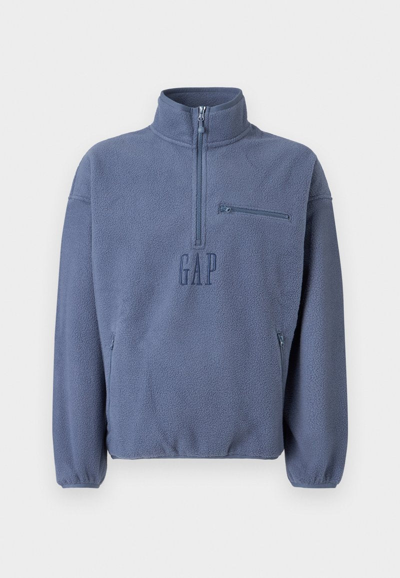 Hellblauer Fleece-Pullover mit hohem Kragen, halbem Reißverschluss und Brusttasche. Verfügt über ein gesticktes "GAP"-Logo und elastische Bündchen.
