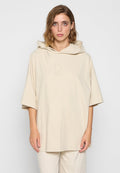 Beige übergroßer Hoodie mit glattem Baumwolltextil, besticktem Logo auf der Brust und einer großen Kapuze. Verfügt über breite Ärmel und eine lockere Passform.