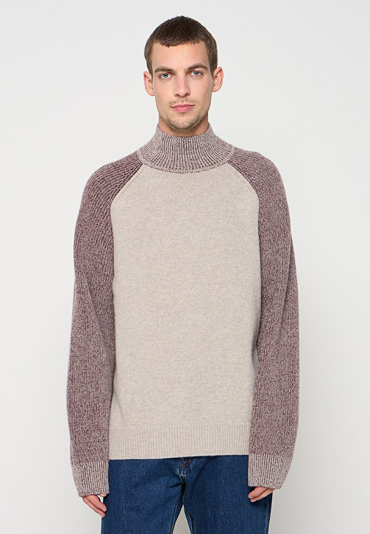 Gestrickter Pullover mit hohem Kragen, bestehend aus einem beigen Körper und kastanienbraunen, strukturierten Raglanärmeln, mit gerippten Bündchen und Saum. Lässige Passform.