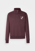 Burgunderfarbener Pullover mit hohem Kragen, halbem Reißverschluss und einem weißen Schildlogo auf der linken Brust. Weicher Stoff mit gerippten Bündchen.