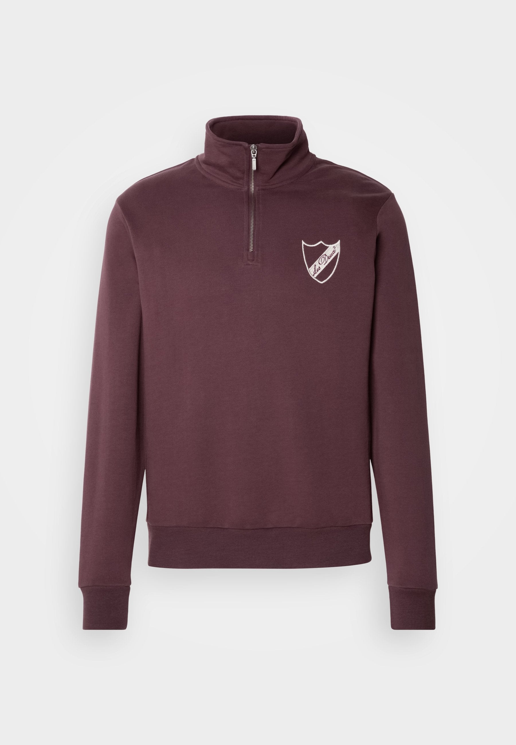 Burgunderfarbener Pullover mit hohem Kragen, halbem Reißverschluss und einem weißen Schildlogo auf der linken Brust. Weicher Stoff mit gerippten Bündchen.