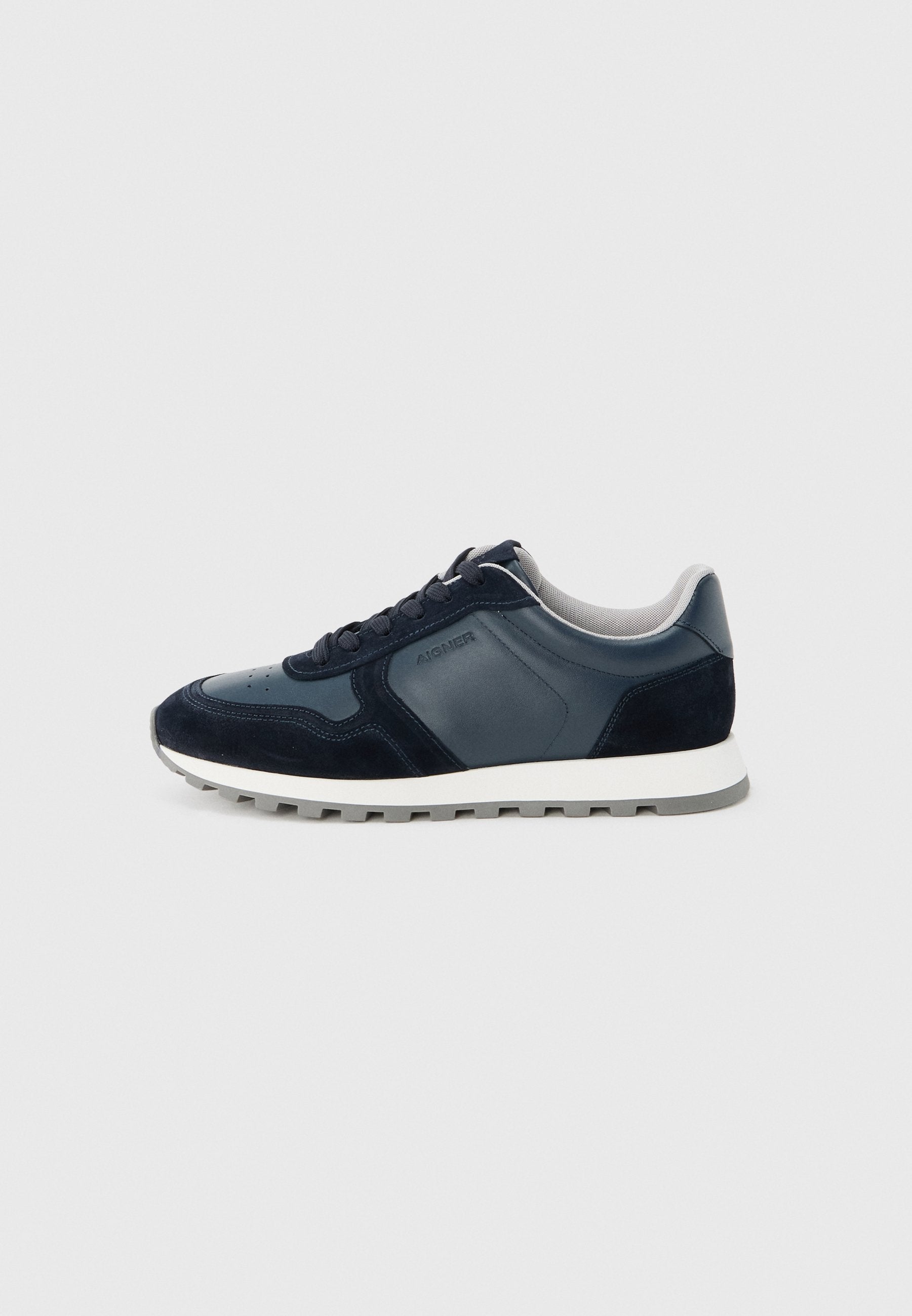 Dunkelblauer und grauer Freizeitsneaker mit Schnürverschluss vorne, gepolstertem Kragen und weißer Sohle mit grauem Profil, von der Innenseite gezeigt.