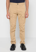 Beige Cargohose mit geradem Schnitt, aus Baumwolle, mit zwei Seitentaschen und Knopfverschluss. Kombiniert mit schwarzen Schuhen.