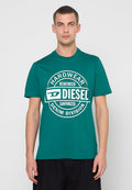 Grünes Baumwoll-T-Shirt mit kurzen Ärmeln, das ein rundes weißes Grafiklogo mit dem Text „HARDWEAR REINFORCED SANFORIZED DENIM DIVISION“ zeigt.