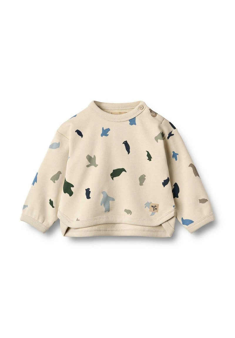 Beiger Baumwollpullover mit langen Ärmeln, unregelmäßigen bunten Tiermustern in Blau, Grün und Schwarz sowie einem Rundhalsausschnitt mit Druckknöpfen.
