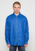 Leichte blaue Jacke mit Reißverschluss, Rückenschnitt, langen Ärmeln und einem dezenten Glanz. Mit kleinem Logo am Saum.