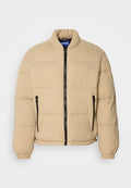 Beige Daunenjacke mit hohem Kragen, Reißverschluss vorne und zwei Reißverschlusstaschen. Mit gestepptem Muster und elastischen Bündchen. Logo auf der Brust.