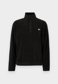 Schwarzer Fleecepullover mit hohem Kragen, ausgestattet mit einer Drei-Knopf-Verschlussleiste, Seitentaschen und einem kleinen Logo auf der linken Brustseite. Weiche Textur.