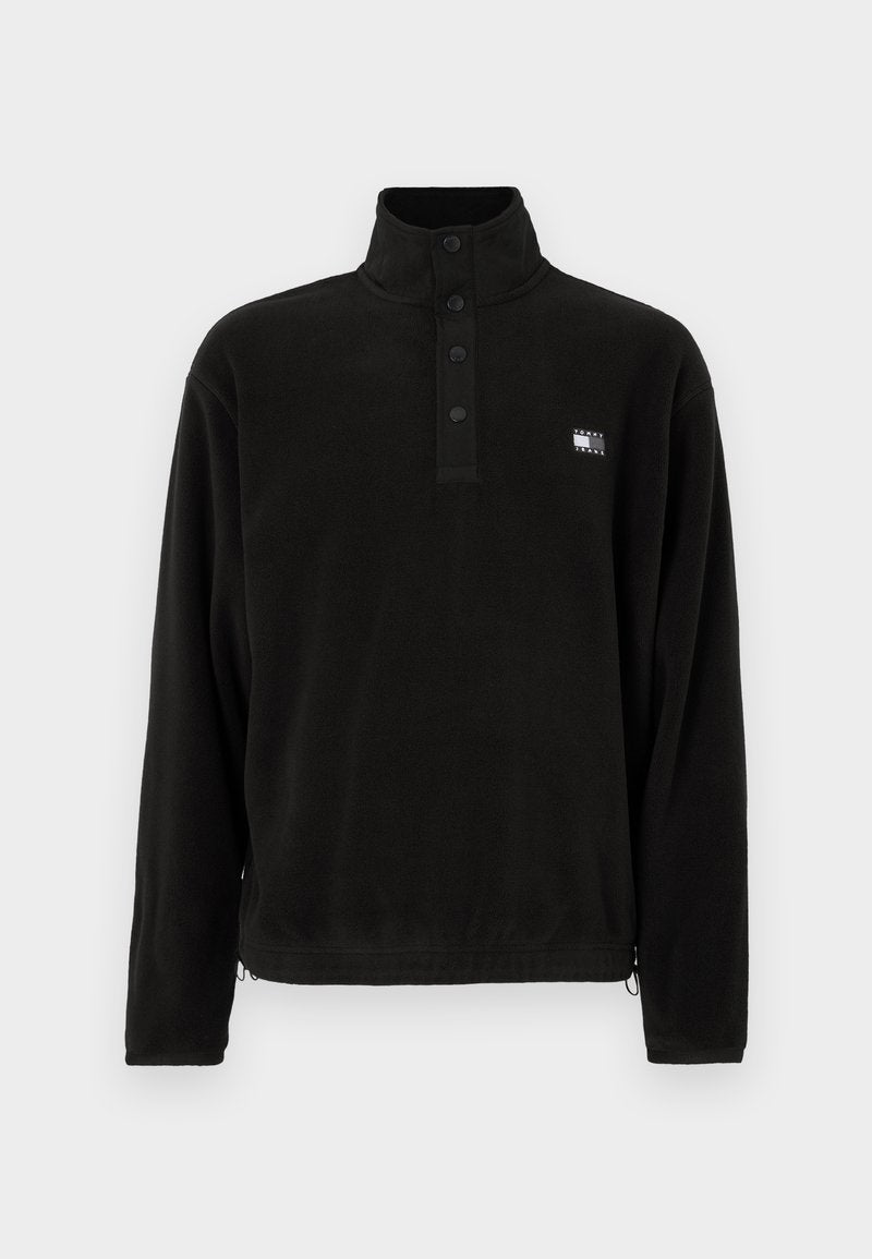 Schwarzer Fleecepullover mit hohem Kragen, ausgestattet mit einer Drei-Knopf-Verschlussleiste, Seitentaschen und einem kleinen Logo auf der linken Brustseite. Weiche Textur.
