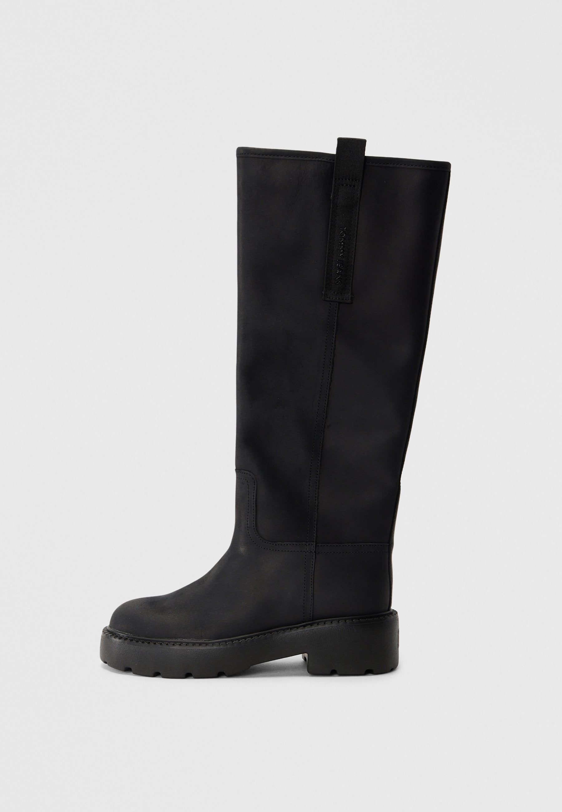 Schwarze knöchelhohe Stiefel aus glattem Leder mit runder Zehenpartie, dicker Sohle mit Profil und einer Schlaufe hinten.