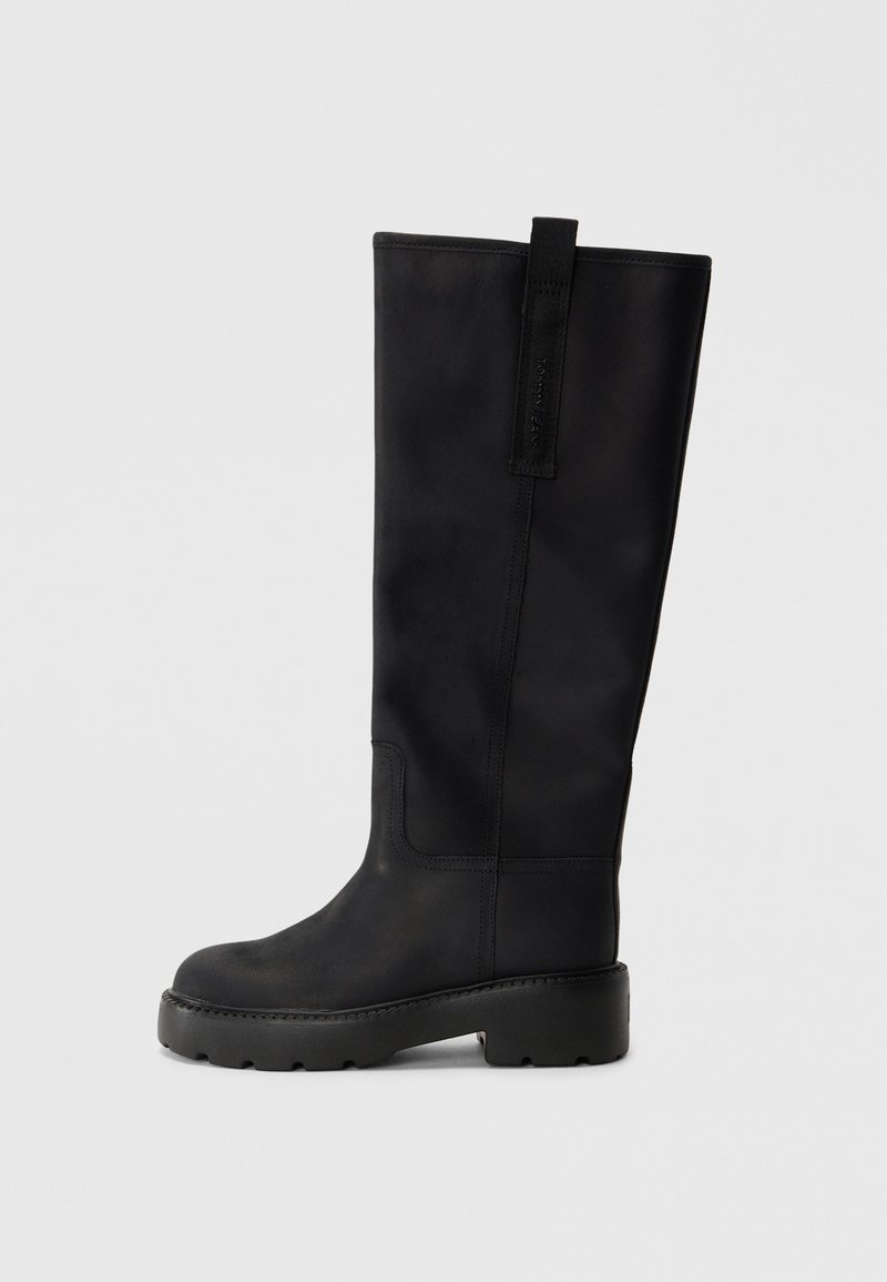 Schwarze knöchelhohe Stiefel aus glattem Leder mit runder Zehenpartie, dicker Sohle mit Profil und einer Schlaufe hinten.